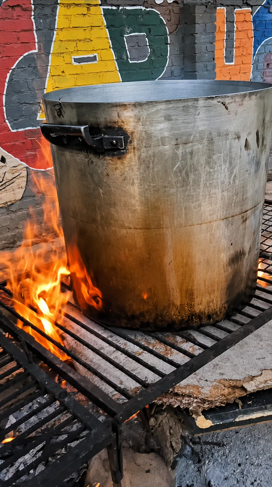 La olla grande al fuego sobre la parrilla del patio.